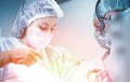 Female surgeon with operating assistants. Surgeons during work. Blue filter. Modern medicine with professional doctors. Royalty Free Stock Photo