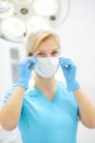 The female surgeon puts on medical face mask. Doctor is preparing for surgery in operation room Royalty Free Stock Photo