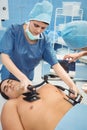 Female surgeon resuscitating an unconscious patient with a defibrillator