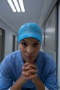 Female surgeon sitting with joined hands in the corridor of hospital Royalty Free Stock Photo