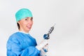 Female surgeon smiling, holding antique, old fashioned medical drill Royalty Free Stock Photo