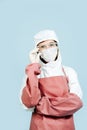 Surgeon in white costume covering all skin wearing red leather apron and sleeves