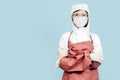 Surgeon standing with her hands crossed with red leather apron and sleeves