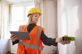 Female Surveyor With Digital Tablet Measuring Room With Laser Measure