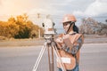 Female Surveyor or Engineer making measure on the highway.