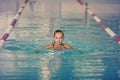 A female swimmer in indoor sport swimming pool. girl in pink sweimsuit in water