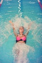 A female swimmer in indoor sport swimming pool. smiling girl in pink sweimsuit