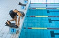 Female swimmer preparing and jumping off the starting block Royalty Free Stock Photo