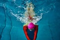Female swimmer in a red suit and glasses sunk into the water to make a U-turn. Royalty Free Stock Photo