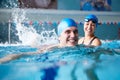 Female Swimming Teacher Giving Man One To One Lesson In Pool