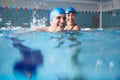 Female Swimming Teacher Giving Man One To One Lesson In Pool