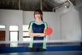 Female table tennis player holding paddle with arms crossed Royalty Free Stock Photo