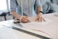 Female Tailor Making Sewing Patterns On Table