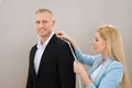 Female Tailor Taking Measurement Of Suit