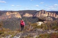 Female taking in magnificent vistas of sheer sandstone cliffs