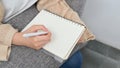 Female taking notes on spiral notepad, hand writing something on blank paper