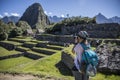 Female taking pictures of ruins of historic sanctuary of Machu Picchu in Cusco, Peru