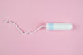 Female tampon on a pink background. Hygienic white tampon for women. Cotton swab. Menstruation