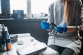 Female tattooer prepares tattoo machine in salon Royalty Free Stock Photo