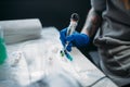 Female tattooist hands holds tattoo machine