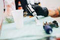 Female tattooist preparing the dyes she`s going to work with.