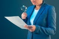 Female tax inspector looking at document with magnifying glass Royalty Free Stock Photo