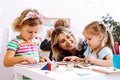 Female teacher with children have fun in development center. Writing, reading lessons and learn ABC by cubes. Adoption Royalty Free Stock Photo