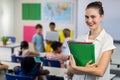 Female teacher with files standing in classroom Royalty Free Stock Photo