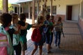 Female teacher with group of schoolchildren walking a outside corridor at an elementary school Royalty Free Stock Photo