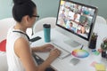 Female teacher having a video conference with multiple students on computer at home Royalty Free Stock Photo