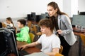 Female teacher helping focused teenage student in computer lab Royalty Free Stock Photo