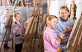 Female teacher helping girl during painting class