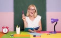 Female teacher at her desk marking students work. Pretty teacher smiling at camera at the school. University student Royalty Free Stock Photo