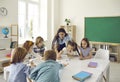 Female teacher and junior high school students have fun putting together puzzles in class. Royalty Free Stock Photo