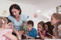 Female Teacher with kids in biology class at elementary school conducting biology or botanical scientific experiment Royalty Free Stock Photo