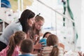 Female teacher with kids in geography class looking at globe. Side view of group of diverse happy school kids with globe Royalty Free Stock Photo