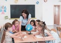 Female teacher with kids in geography class looking at globe. Side view of group of diverse happy school kids with globe Royalty Free Stock Photo