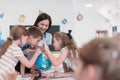 Female teacher with kids in geography class looking at globe. Side view of group of diverse happy school kids with globe Royalty Free Stock Photo