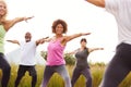 Female Teacher Leading Group Of Mature Men And Women In Class At Outdoor Yoga Retreat Royalty Free Stock Photo