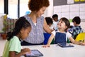 Female Teacher With Multi-Cultural Elementary School Pupils Using Digital Tablets At School Royalty Free Stock Photo