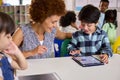 Female Teacher With Multi-Cultural Elementary School Pupils Using Digital Tablets At School Royalty Free Stock Photo