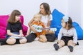 Female teacher plays a guitar with a group of kids Royalty Free Stock Photo