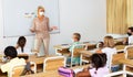 Female teacher in protective mask giving lesson to children Royalty Free Stock Photo