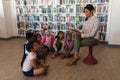 Female teacher reading a story to schoolkids Royalty Free Stock Photo