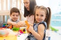 Teacher teaches children handcraft in kindergarten or playschool Royalty Free Stock Photo
