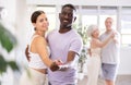 Girl teacher dances pair dance with african male student of fitness class Royalty Free Stock Photo