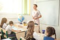 Female teacher teaching group of teenagers in high school lesson