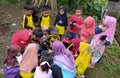 a female teacher is teaching her students how to grow crops in the garden