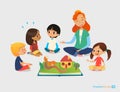 Female teacher tells fairy tales using pop-up book, children sit on floor in circle and listen to her. Preschool activities and ea