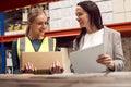 Female Team Leader With Clipboard In Warehouse Training Intern Standing By Shelves Royalty Free Stock Photo